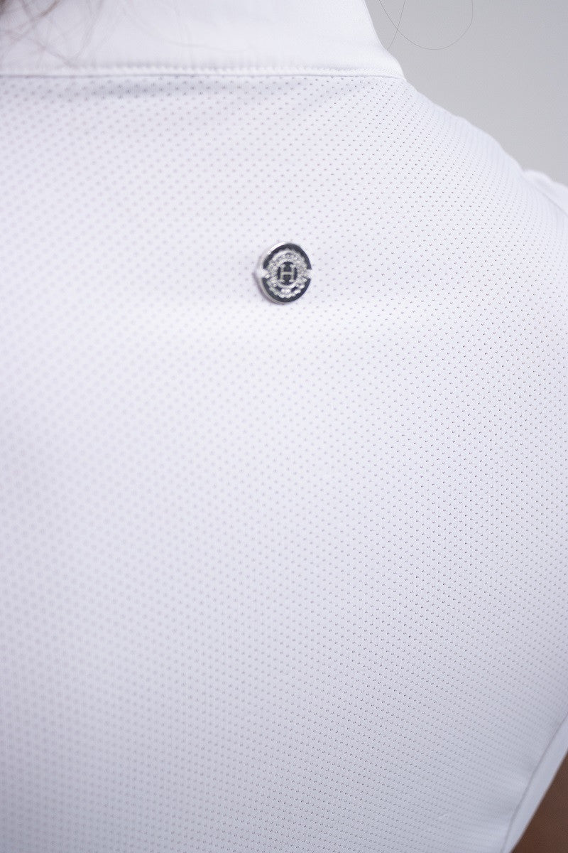 Close-up of a white textured shirt with a button on a light gray background