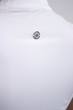 Close-up of a white textured shirt with a button on a light gray background