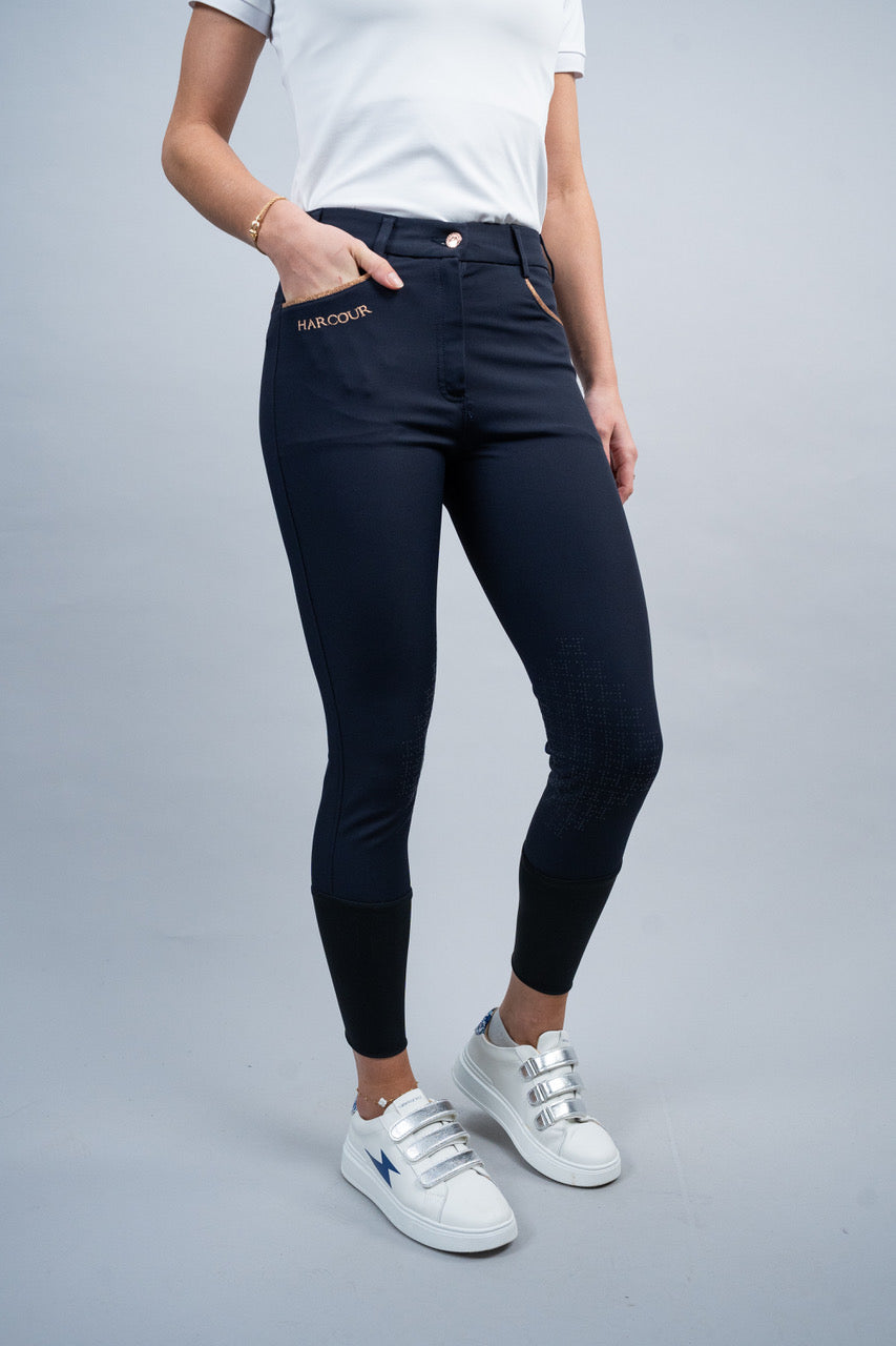 Person wearing navy blue breeches with a brand logo on a gray background