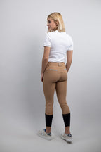 Woman wearing tan riding pants with a white background