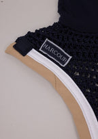 Black lace garment with a visible 'HARCOUR' label on a beige background