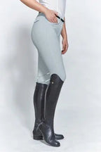 Person wearing light gray riding pants and black riding boots on a white background