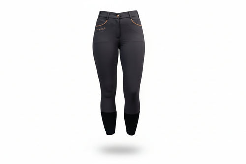  dark gray riding pants with white sneakers on a gray background