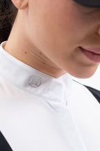 Close-up of a person wearing a white shirt with a small decorative button on the collar.
