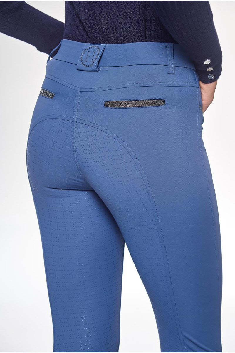 Blue riding pants with a textured pattern on a white background