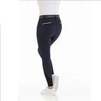 Person wearing navy riding pants with a white background