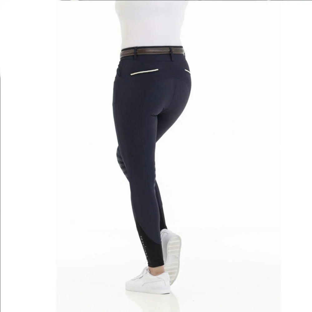 Person wearing navy riding pants with a white background