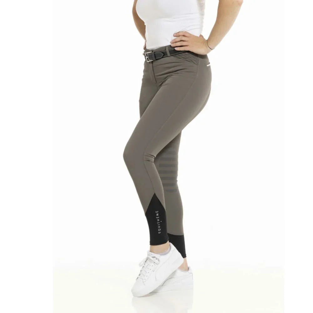 Person wearing gray riding pants with a white background