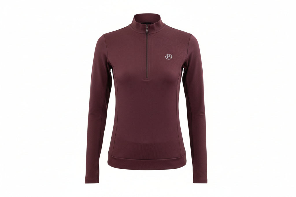 Woman wearing a maroon long-sleeve athletic top with a small logo on a white background