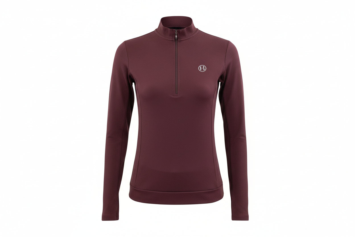 Woman wearing a maroon long-sleeve athletic top with a small logo on a white background